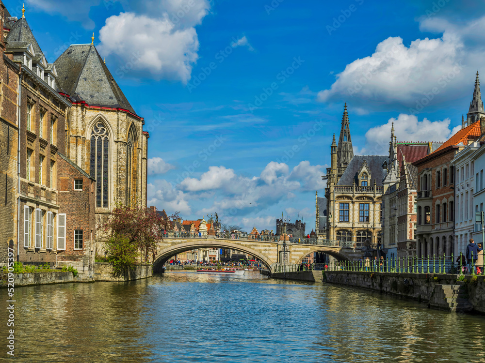 Arched stone bridge and Historic medieval building and on Leie river in Ghent, Belgium
