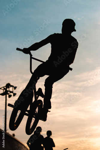 Silhouette of acrobat cyclist on track