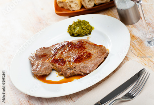 Tasty fried beef entrecote served with traditional Italian pesto sauce..