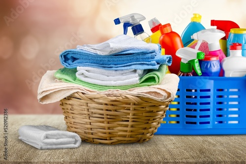 Group of chemical and alternative laundry products on a table with washed clothes on the desk © BillionPhotos.com