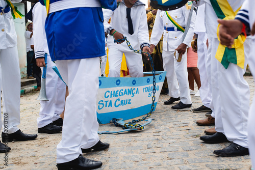  Men, women and children, members of the cultural group Chegança dos Marujos, dance and sing in costumes during a performance at the streets of Saubara, Bahia. photo