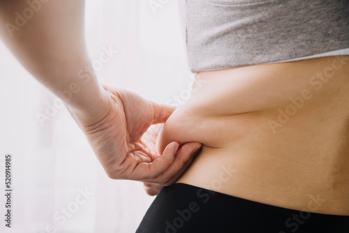 Bild auf Leinwand Beautiful fat woman with tape measure She uses her hand to squeeze the excess fat that is isolated on a white background