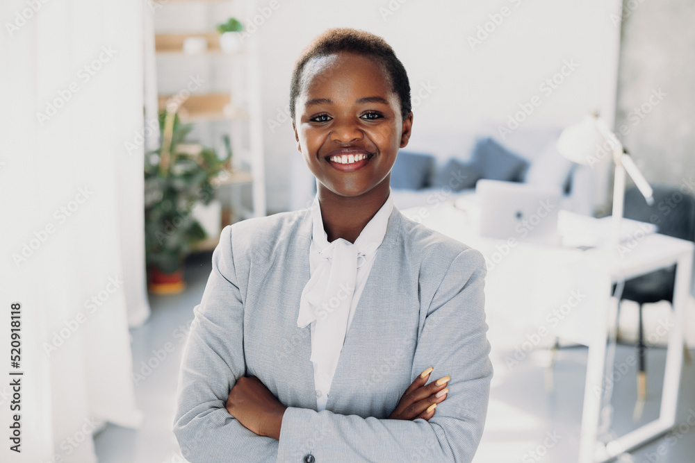 Portrait of a successful african-american business woman standing with crossed arms, looking at the camera. Beautiful young girl. Closeup portrait. Positive Portrait of a successful african-american business woman standing with crossed arms, looking at the camera. Beautiful young girl. Closeup portrait. Positive