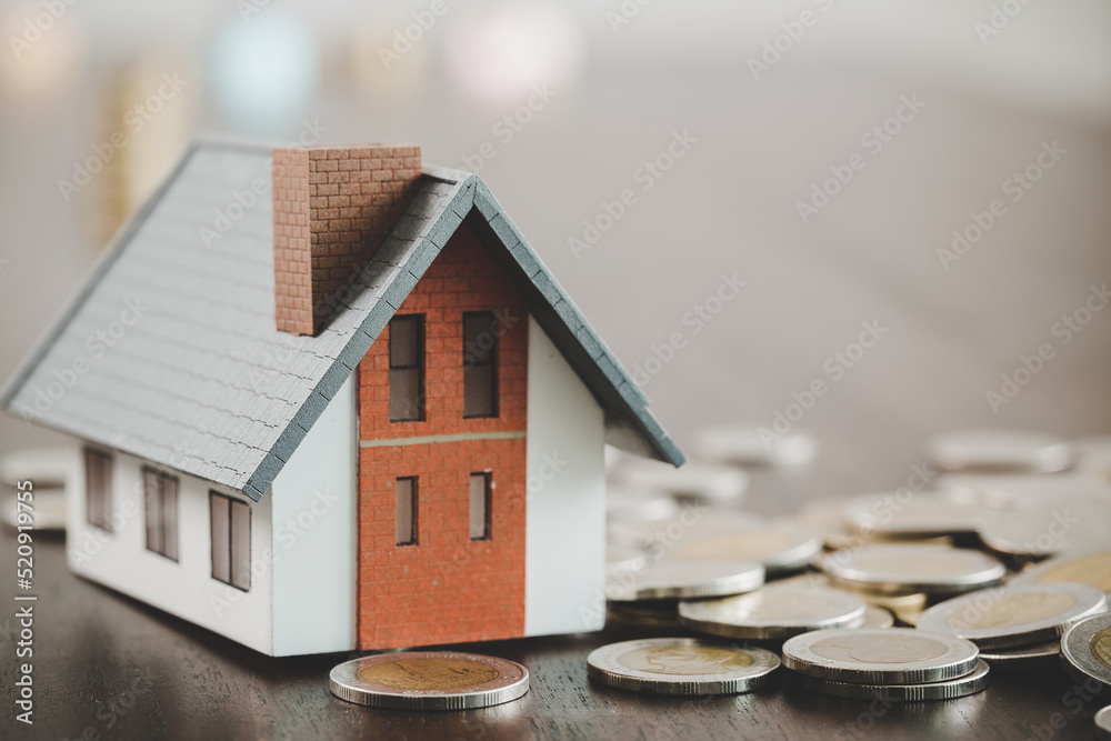 House model and money coins stacks on blur table background. Savings plans for home, loan, investment, mortgage, finance and banking about house concept. House model and money coins stacks on blur table background. Savings plans for home, loan, investment, mortgage, finance and banking about house concept.