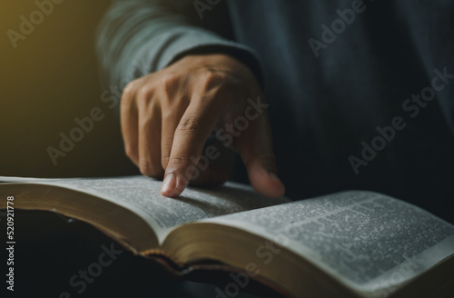 Photography Close-up of Christian man's hands while reading the Bible outside