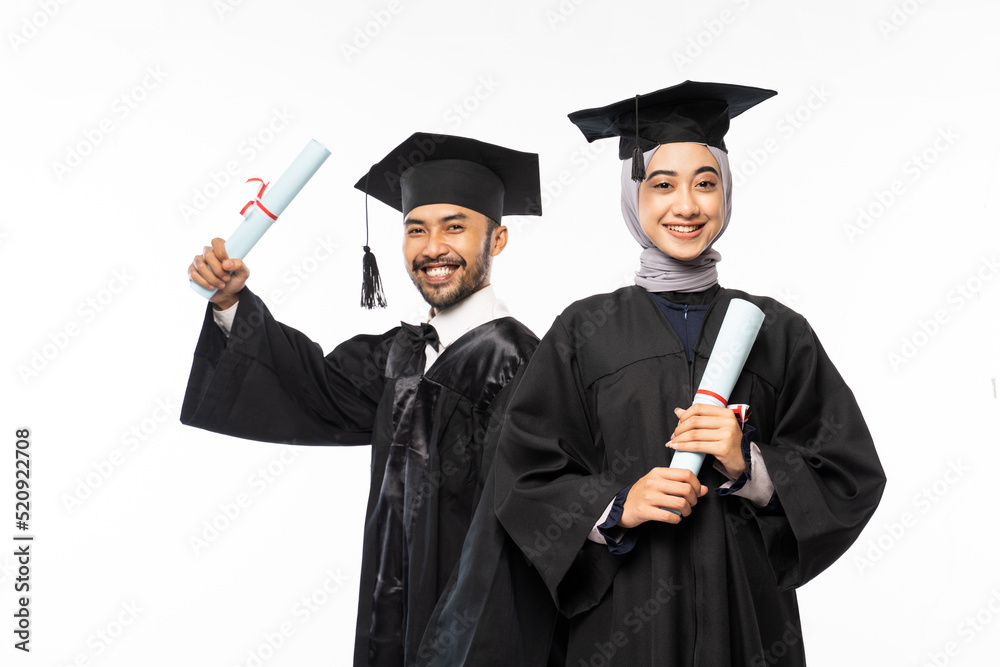 Beautiful woman wearing a toga standing in front of friend holding a roll of certificate on an isolated background Beautiful woman wearing a toga standing in front of friend holding a roll of certificate on an isolated background