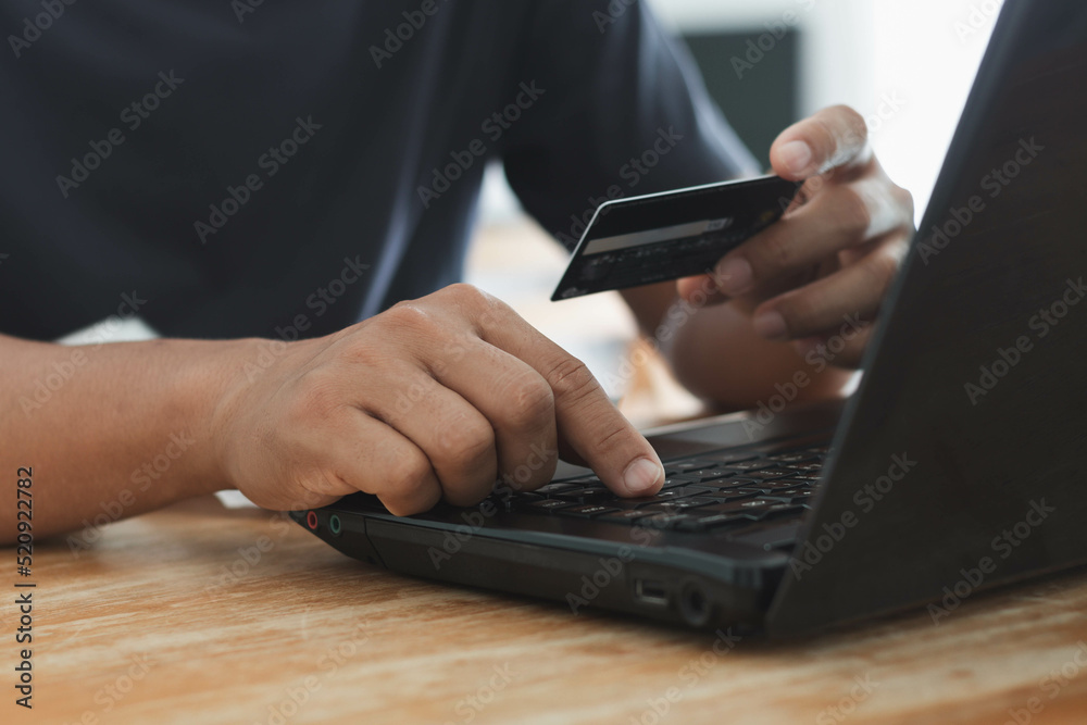 Businessman using laptop computer with a credit card making an online order. Business, online shopping, e-commerce, internet banking, spending money, online payment, working from home concept. Businessman using laptop computer with a credit card making an online order. Business, online shopping, e-commerce, internet banking, spending money, online payment, working from home concept.