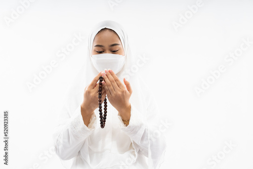 Woman hijab wearing ihram clothes performing al fatihah prayer on isolated background photo
