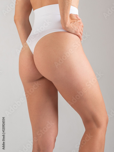 Attractive young woman standing in underwear, belly and hips. vertical photo