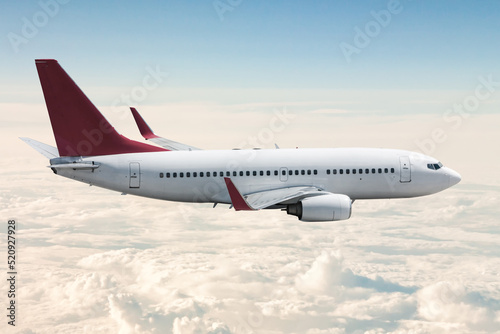 Passenger jet plane flies in the air above the clouds