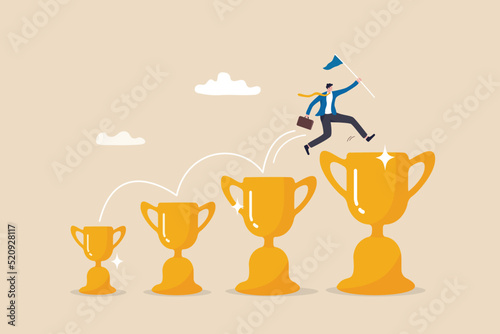 Small win or achievement to motivate to achieve bigger goal, strategy or inspiration to success, victory or win award concept, confident businessman jumping from small win trophy to get bigger one.