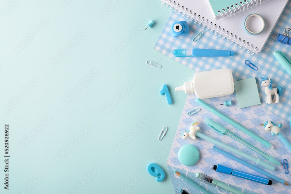 Background with various stationery of blue shades lying on the side on a light blue background. Background with various stationery of blue shades lying on the side on a light blue background.