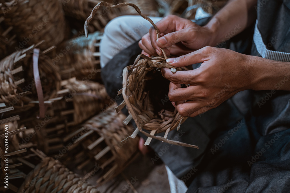 close up of asian craftsman hand weaving crafts on a brick house background