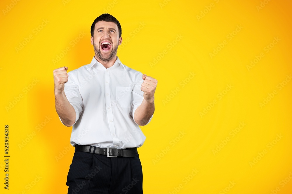 Overjoyed happy man screaming yes in ecstatic, raising fists up, celebrating good luck, victory. Goal achievement concept Overjoyed happy man screaming yes in ecstatic, raising fists up, celebrating good luck, victory. Goal achievement concept