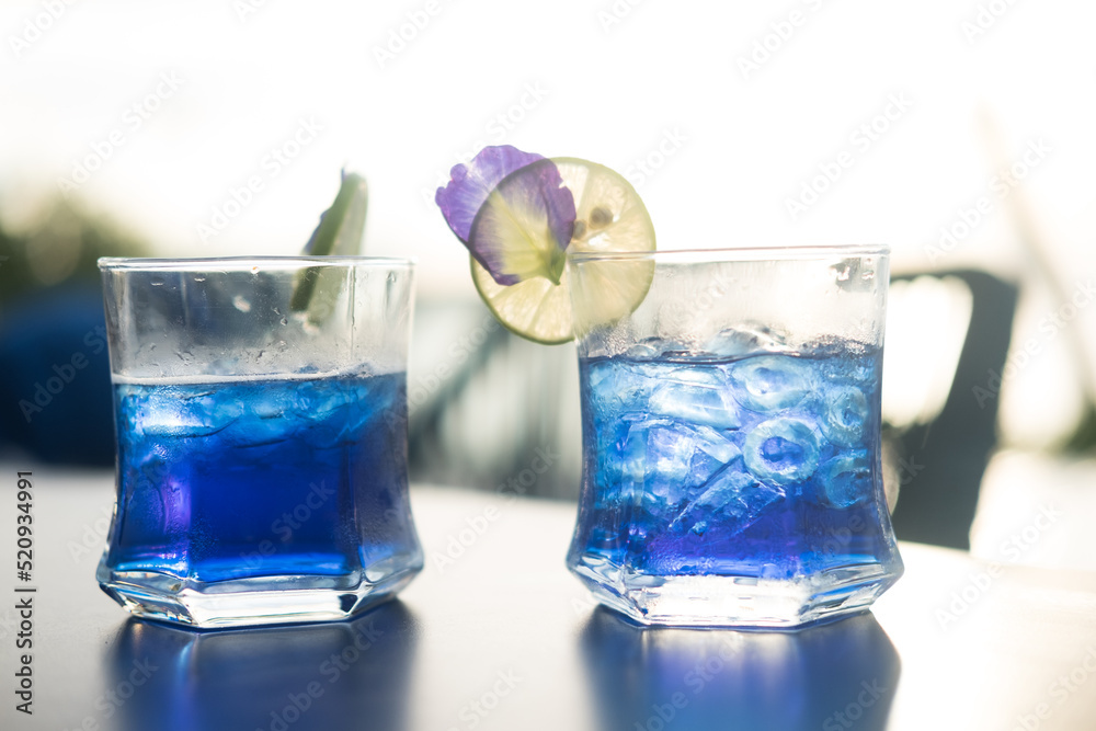 Two glass cups of butterfly pea iced tea. Summer refreshing drink. Two glass cups of butterfly pea iced tea. Summer refreshing drink.