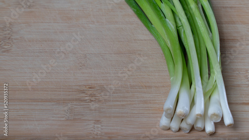 green onions feathers lie on a wooden kitchen board