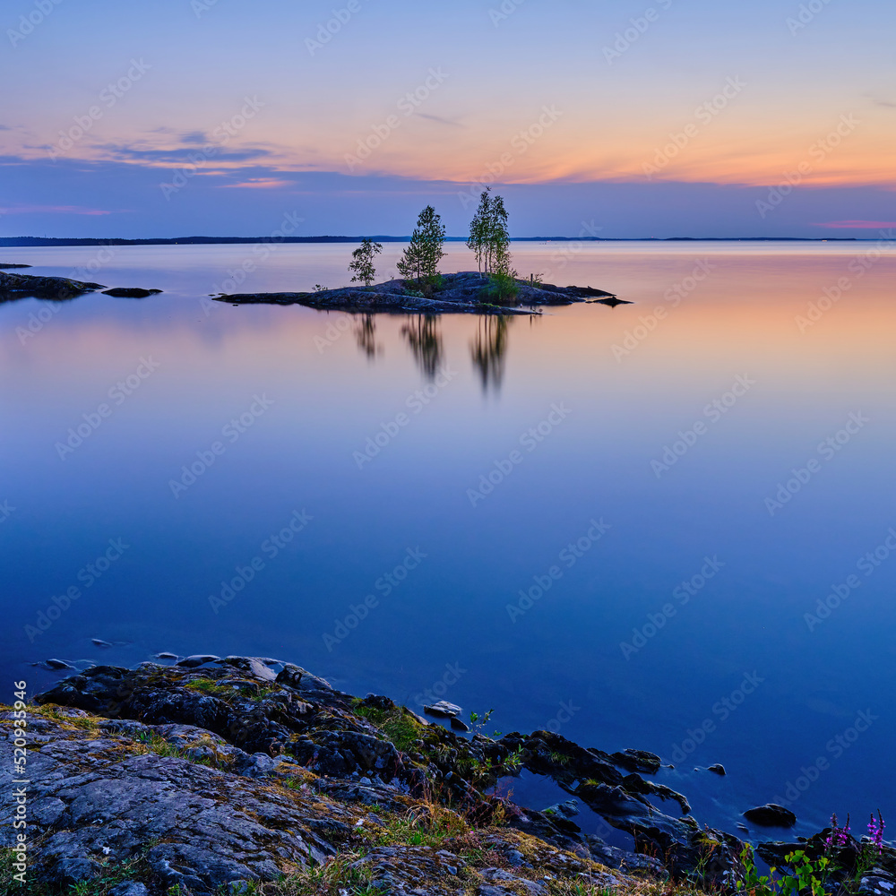 Small island on the calm lake Näsijärvi at night