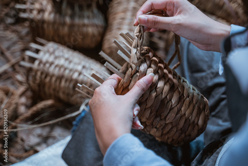 close up of craftswoman hands weaving water hyachinths while making crafts photo