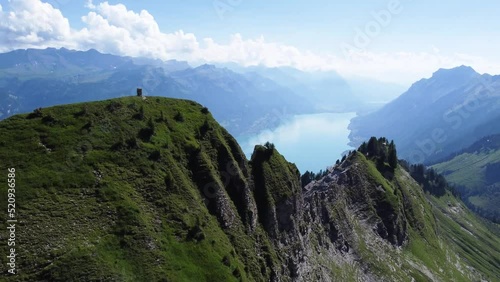 Aerial drone shot of the stunning landscape of the Alps of Switzerland on a clear blue day, overlooking Lake Brienz in the background and some dramatic rock formations in the foreground photo