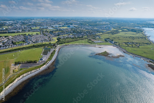 Aerial view on Ballyloughane Strand in Galway city, Ireland. High tide. Blue cloudy sky and ocean water. Popular area with amazing view and footpaths for walk close to Renmore residential area © mark_gusev