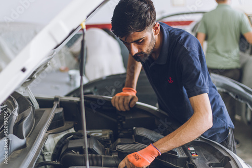 Pakistani or Indian Mechanic repairing a car in garage