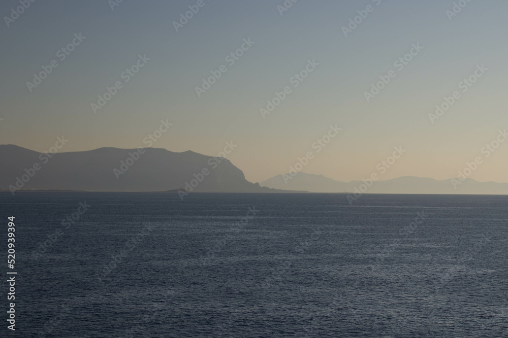 evocative image of sea coast with promontory on the background in Sicily, Italy
