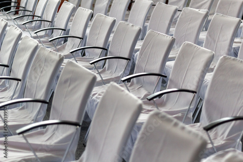 Rows of chairs with white fabric covers