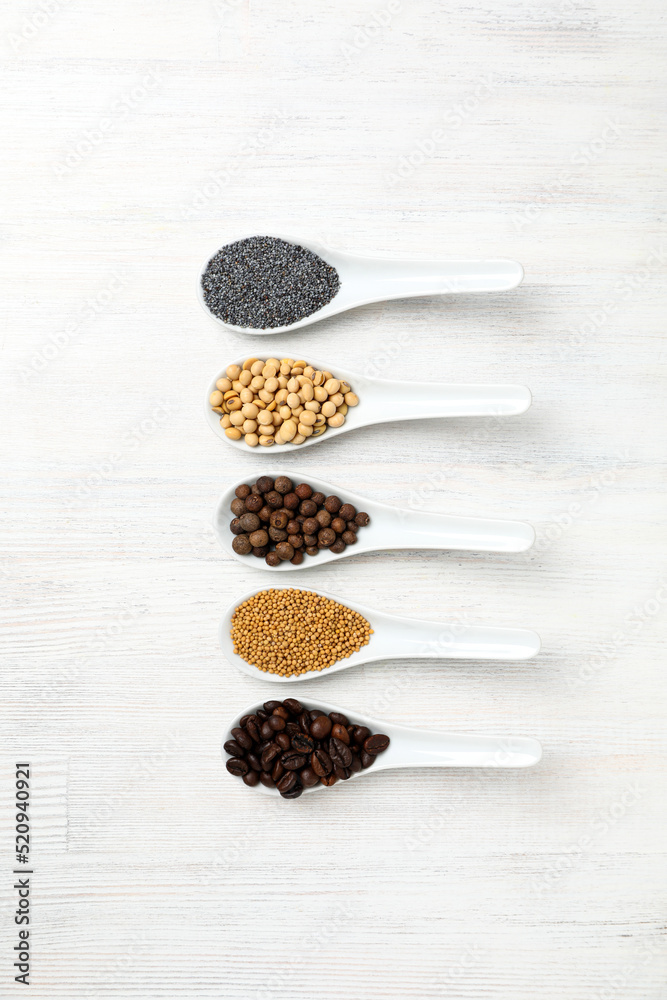 Spoons with different food on white wooden background Spoons with different food on white wooden background