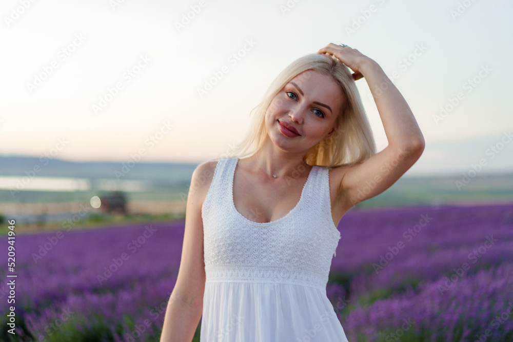Attractive young woman in summer dress standing among the lavender fields Attractive young woman in summer dress standing among the lavender fields