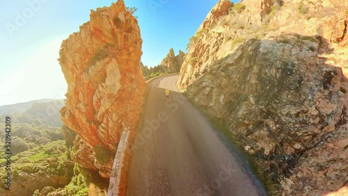 Aerial view of tourist woman walking on D81 route of Calanques of Piana badlands at sunset. Drone view Corsican badlands called Les Calanques in Mediterranean sea by the Porto Ota and UNESCO site. photo