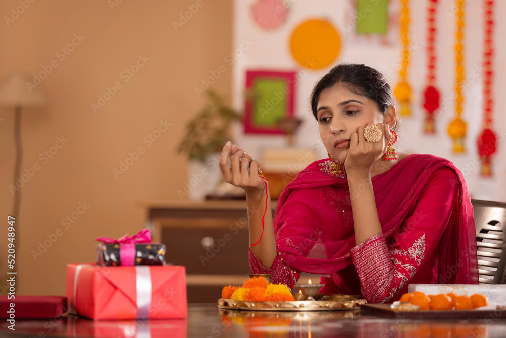 Sister with pooja plate and rakhi waiting alone for her brother on the occasion of Raksha Bandhan Sister with pooja plate and rakhi waiting alone for her brother on the occasion of Raksha Bandhan