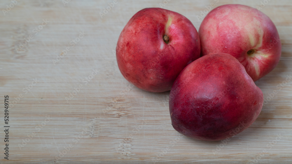 Nectarine fruits three pieces on a wooden background with a place for inscription Nectarine fruits three pieces on a wooden background with a place for inscription