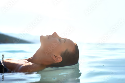 Relax and rest concept. Profile Beauty portrait of Young attractive female model with swimming in the transparent sea water. Natural skin care
