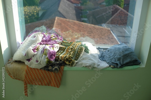 Mukena, Muslim women's clothing for prayer and prayer mats are placed near the window of the prayer room.
