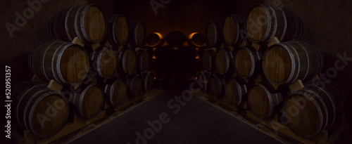 Wine or cognac barrels in the cellar of the winery, Wooden wine barrels in perspective. wine vaults. vintage oak barrels of craft beer or brandy. photo
