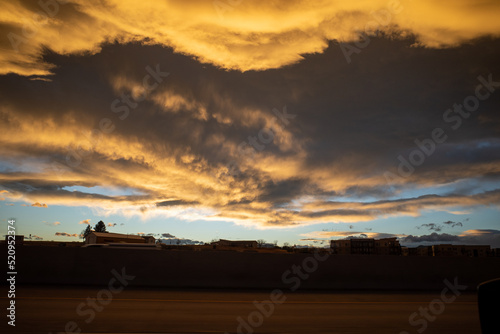 dramatic ominous storm clouds form at sunset over sparse landscape photo