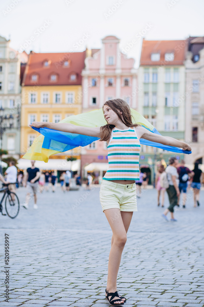 Ukrainian girl with a flag in her hands on the city square.