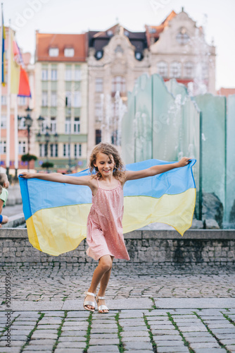 Ukrainian girl with a flag in her hands on the city square. © Nataliia Hrihel