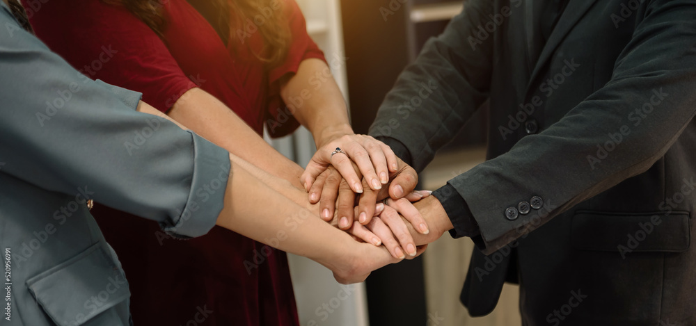 Obraz premium Teamwork business concept of group of three coworkers join hand together during their meeting..