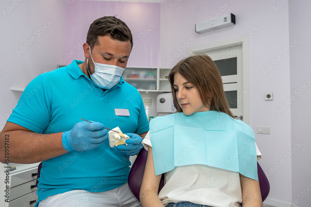 male dentist explains the plan for further dental treatment to  female patient in the clinic