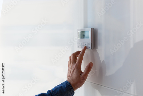 The air conditioning and heating control panel for the apartment and office is located on a white wall. photo