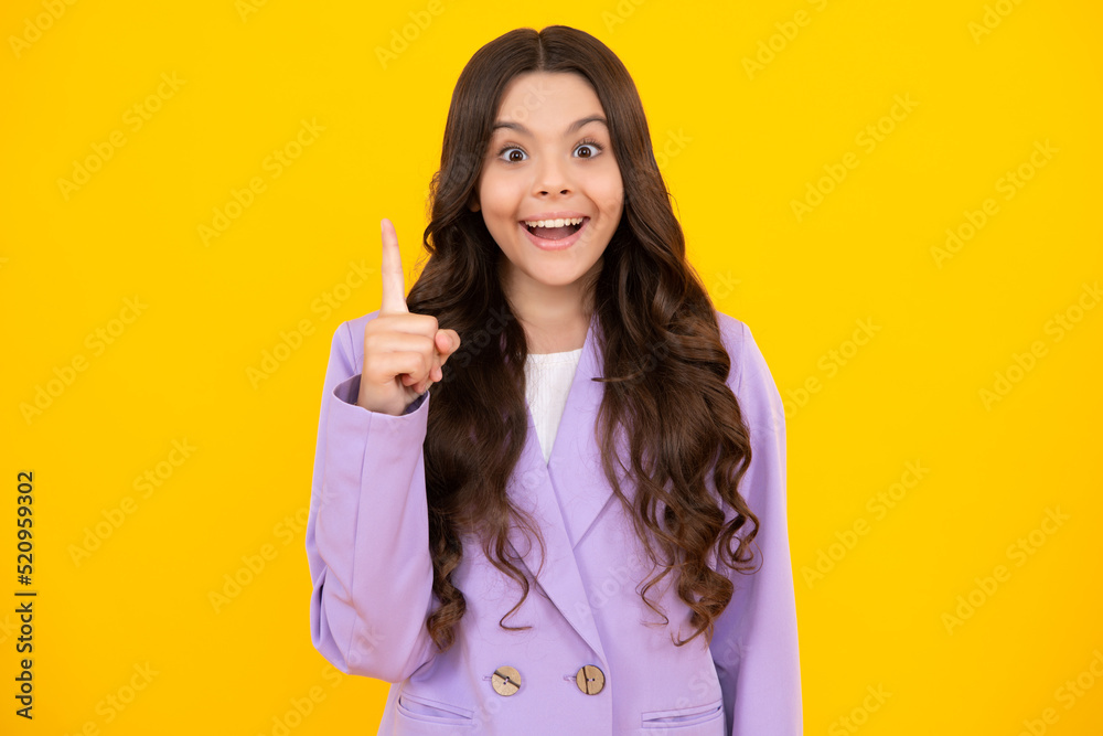 Surprised teenager girl. Funny face of young teenager pointing up with finger, isolated on yellow background. Girl has great new idea. Surprised teenager girl. Funny face of young teenager pointing up with finger, isolated on yellow background. Girl has great new idea.