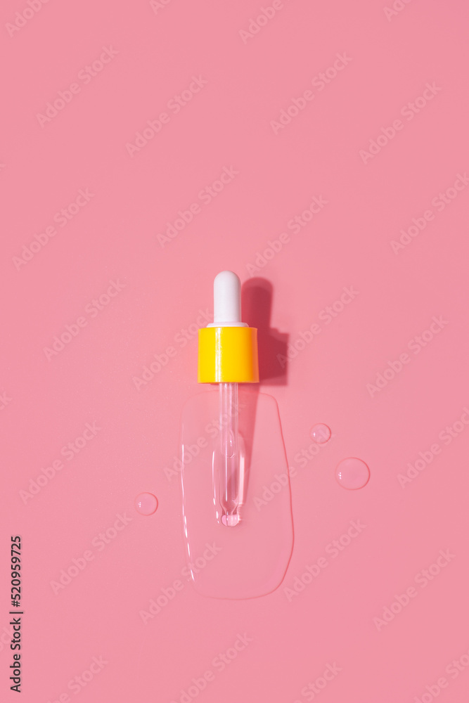 Yellow pipette drops of serum moisturized bottle on pink background. Essence transparent hyaluronic acid Yellow pipette drops of serum moisturized bottle on pink background. Essence transparent hyaluronic acid