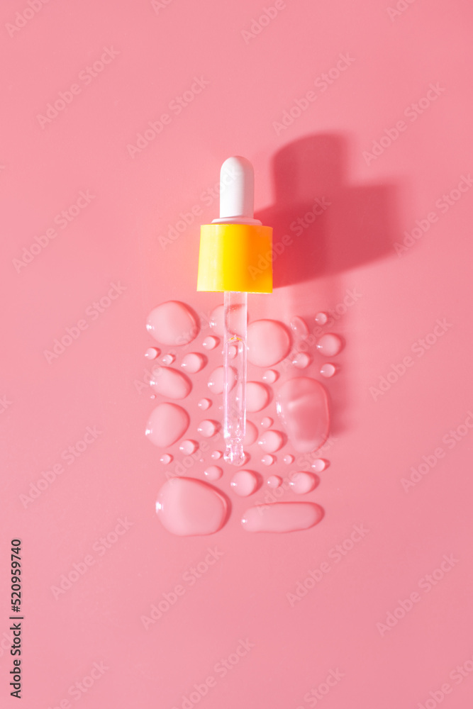Bottle of drops of anti-aging emulsion and glass pipette on light pink surface close upper view. Skincare and dermatological procedures Bottle of drops of anti-aging emulsion and glass pipette on light pink surface close upper view. Skincare and dermatological procedures