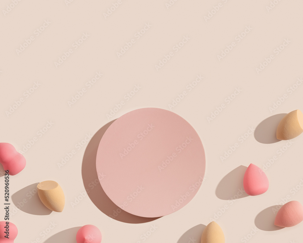 Makeup sponges and geometric pink platform on beige color. Mock up Cosmetic background for product presentation or foundation cream. Top view sponges and podium to show cosmetic products Makeup sponges and geometric pink platform on beige color. Mock up Cosmetic background for product presentation or foundation cream. Top view sponges and podium to show cosmetic products