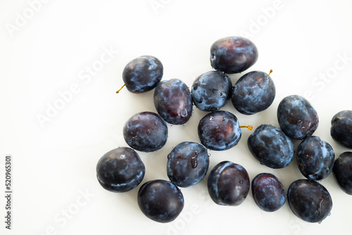 Ripe juicy plums on a white background.