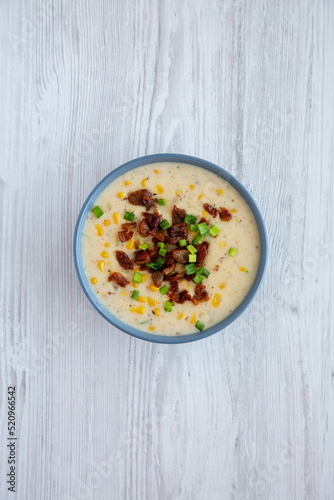 Homemade Corn Chowder with Bacon in a Bowl on a white wooden background, top view. Flat lay, overhead, from above.