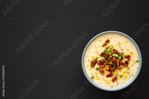 Homemade Corn Chowder with Bacon in a Bowl on a black background, top view. Flat lay, overhead, from above. Copy space.