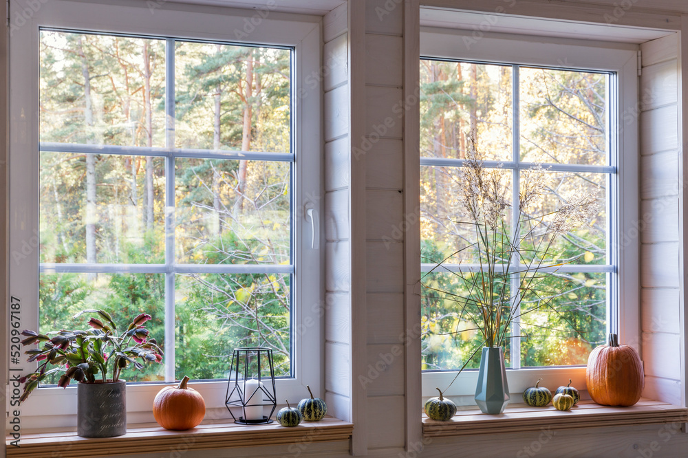 Orange pumpkins on windowsill, candles, autumn leaves and lantern. Scandinavian style Orange pumpkins on windowsill, candles, autumn leaves and lantern. Scandinavian style
