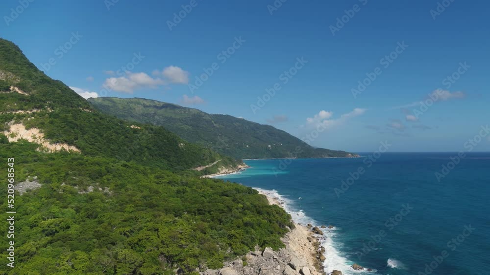 Bright blue ocean off a tropical mountain coastline with a white sandy beach. Palm jungle on the sea peninsula. Summer seascape of wild nature. camera zoom. Bright blue ocean off a tropical mountain coastline with a white sandy beach. Palm jungle on the sea peninsula. Summer seascape of wild nature. camera zoom.
